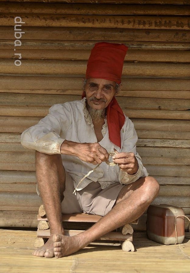 Un tete din Huaulu. Turbanul rosu este insemnul barbatilor naulu. In stanga lui este cutia cu betel, ocupatia preferata a batranilor din sat fiind mestecatul de betel. (Betel = nuca de areca + frunza de betel + praf din scoici, care mestecate au un efect usor narcotic.)