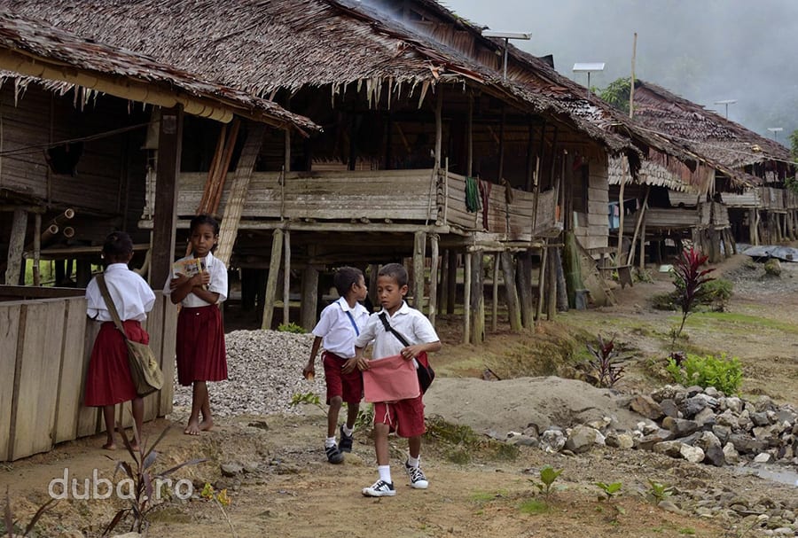 Dimineata, copiii din Huaulu se duc spre scoala, imbracati in uniformele pentru ciclul primar.