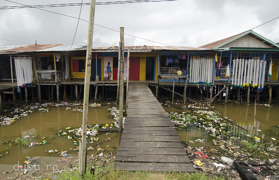 Comertul aduce multe chestii in Papua, nu toate utile. In Agats, ca mai peste tot in Indonezia, deseurile sunt colectate natural. In fundal, magazine care vand plase de pescuit.